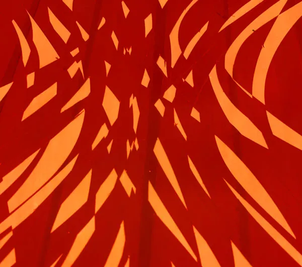 Abstract pattern of orange geometric shapes against a deep red background, warm and bold mood